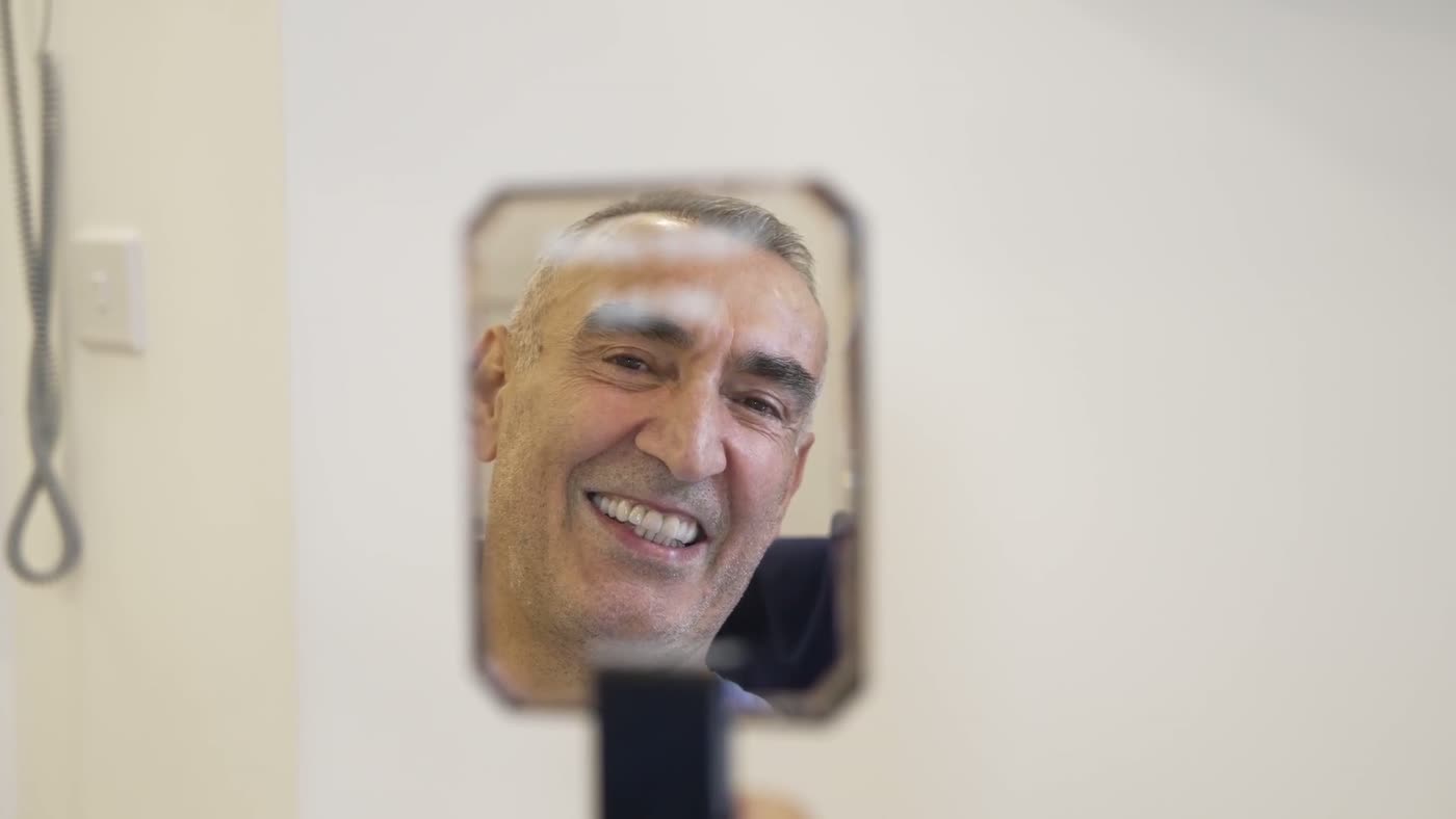Patient checking his new smile in a mirror